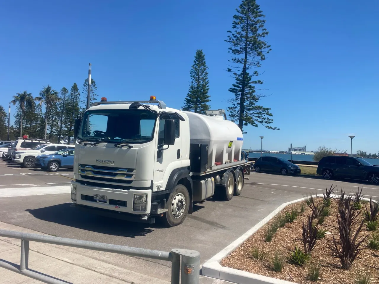 Simon Hull's Isuzu water truck parked at the water's edge near Port Stephens